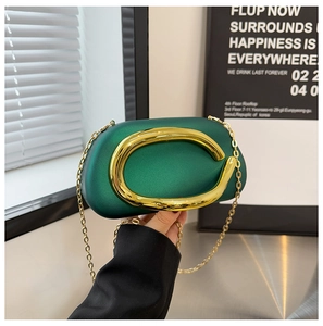 Detail of dark green matte evening bag with large gold C buckle and chain strap