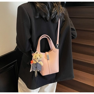 Pink lychee grain bucket bag with cute bear charm and adjustable shoulder strap