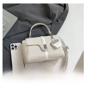Détail du sac à main tressé blanc avec fermoir rotatif argenté et bandoulière ethnique