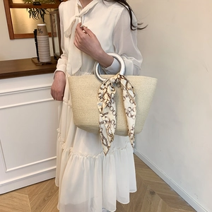 Elegant beige woven tote bag with silver ring handles and silk scarf detail