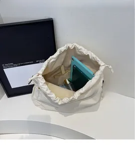 Top view of spacious interior of white canvas drawstring bag with tablet and daily items
