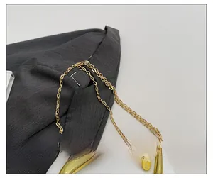 Detailed close-up of a polished gold metal chain strap for a vintage shoulder handbag