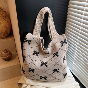 Chic beige knitted tote bag with black bow patterns and wide shoulder straps for women