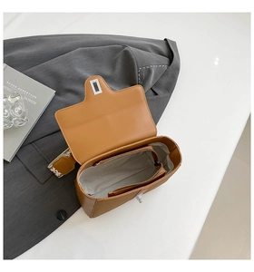 Vue intérieure du sac bandoulière en cuir caramel avec compartiment et poche zippée