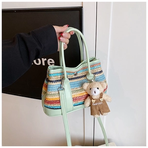 Détail du sac en paille multicolore avec bordure en cuir vert et charmant ours en peluche