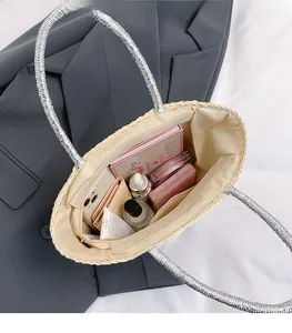 Spacious interior of a woven straw tote bag with silver handles and daily essentials