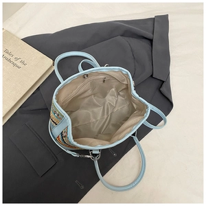 Vue de dessus du sac tissé bleu avec doublure en tissu marron et poche zippée