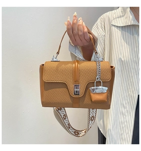 Détail du sac à main marron avec texture tissée et large bandoulière de style bohème
