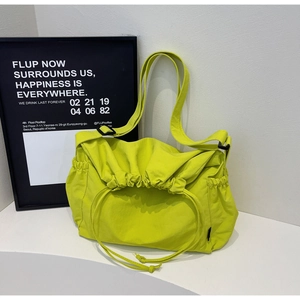 Detail of lime green drawstring hobo bag with adjustable black strap and soft folds