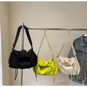 Detail of adjustable nylon straps and drawstring folds on three colorful canvas bags