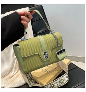 Détail du sac vert clair avec rabat tissé, fermoir rotatif et bandoulière brodée ethnique