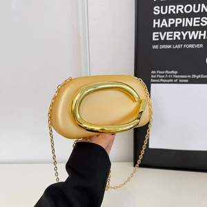 Champagne gold metallic clutch bag with oversized oval handle and fine chain strap