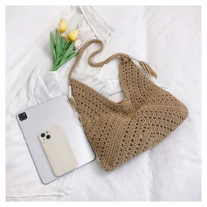 Detail of vintage hand-woven shoulder bag showing intricate hollow crochet texture and tassel