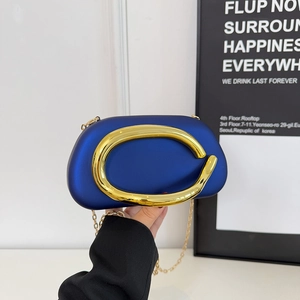 Minimalist royal blue hardshell crossbody bag with decorative gold metal ring handle