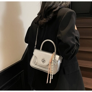 Silver metallic crossbody bag featuring a swivel lock and silk scarf detail on handle