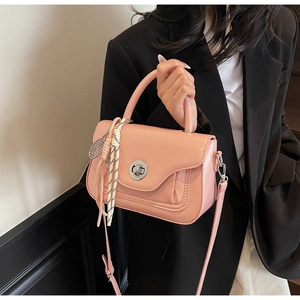 Pink crossbody bag with silk scarf handle detail and silver tennis racket charm