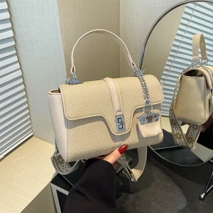 Sac à main tissé beige avec garniture en cuir, fermoir rotatif et large bandoulière à motifs