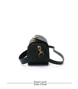 Detail view of black textured leather bag with gold metal hooks and stitching