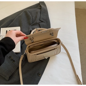 Detail view of the beige crossbody bag interior featuring multiple compartments and silver lock