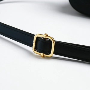 Detail of black leather shoulder strap with gold buckle and fine stitching craftsmanship