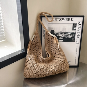 Retro woven straw shoulder bag with tassel accents and textured crochet pattern in brown