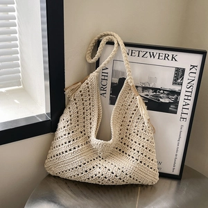 Vintage beige hand-woven crochet hobo bag with tassel and textured knitting pattern