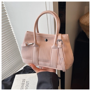 Detailed close-up of pink pleated bucket bag with silver metal lock and round handles