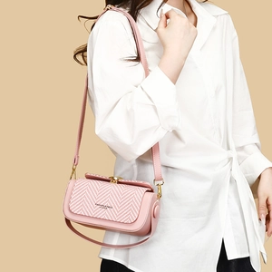 Pink crossbody bag with herringbone weave flap and gold hardware on model