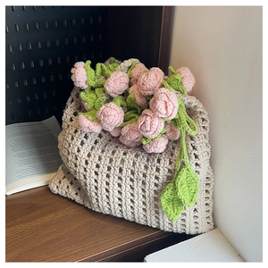 Gros plan d'un sac seau au crochet fait main avec des détails floraux de roses roses