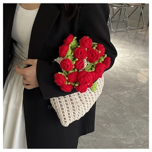 Détail de roses rouges au crochet faites à la main dans un sac seau tricoté blanc