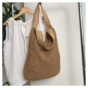 Détail d'un sac cabas tressé kaki montrant la texture ajourée et la bandoulière renforcée