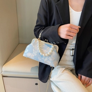 Detail of floral jacquard shell bag with large pearl handle and gold chain strap