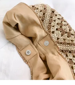 Close-up of silver magnetic clasp and beige lining on woven paper shoulder bag