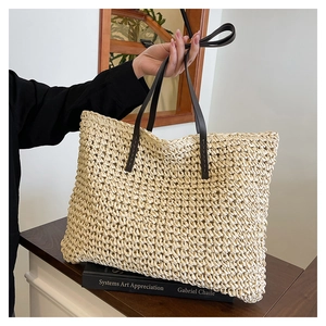Détail du sac cabas tissé crème avec poignées en cuir marron sur une table en bois