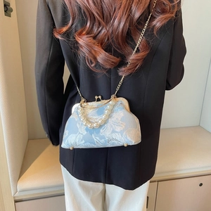 Detail of light blue floral jacquard shell bag with pearl handle and gold chain strap