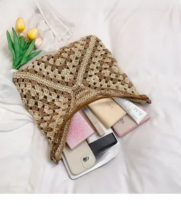 Macro detail of spacious woven crochet tote bag with leather handles and interior items