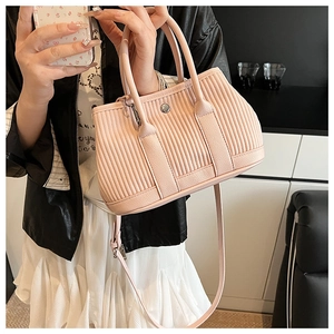 Detail of pink pleated bucket bag with lychee texture and silver metal hardware accents