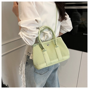 Detail view of light green pleated PU leather bucket bag with silver metal buckle and strap