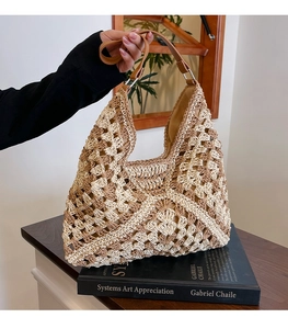 Detail of hand-woven crochet shoulder bag with beige geometric hollow patterns