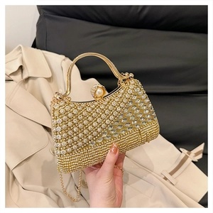Detail of gold rhinestone clutch bag with pearl clasp and sparkling wave pattern