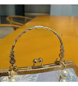 Detail of vintage blue jacquard shell bag with gold metal handle and large pearl drop