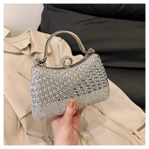 Detail of silver rhinestone evening bag with oversized pearl clasp and metal handle