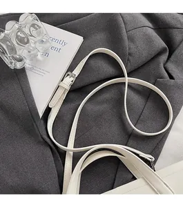 Close-up of white leather shoulder strap with adjustable silver metal buckle detail