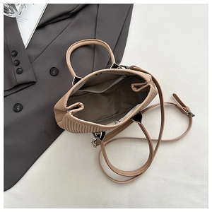 Top view of khaki pleated bucket bag interior showing spacious compartment and strap