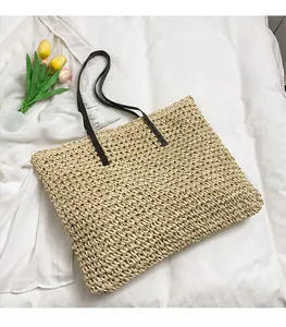 Détail de la texture du sac cabas en paille tressée avec ses fines anses brunes