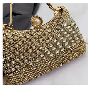 Detail of gold evening clutch with sparkling rhinestones and a large pearl clasp
