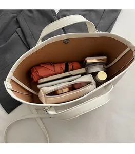 Top view showing the large interior capacity of this beige bucket bag with daily items