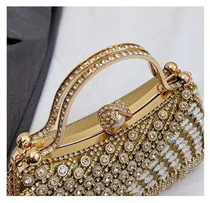 Detail of gold evening clutch featuring sparkling rhinestones and elegant pearl clasp