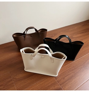 Detailed view of minimalist bucket bags in brown, black, and beige with round handles