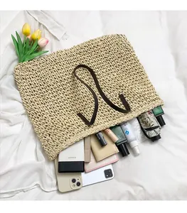 Vue de dessus du grand sac cabas tissé beige montrant le rangement des objets du quotidien